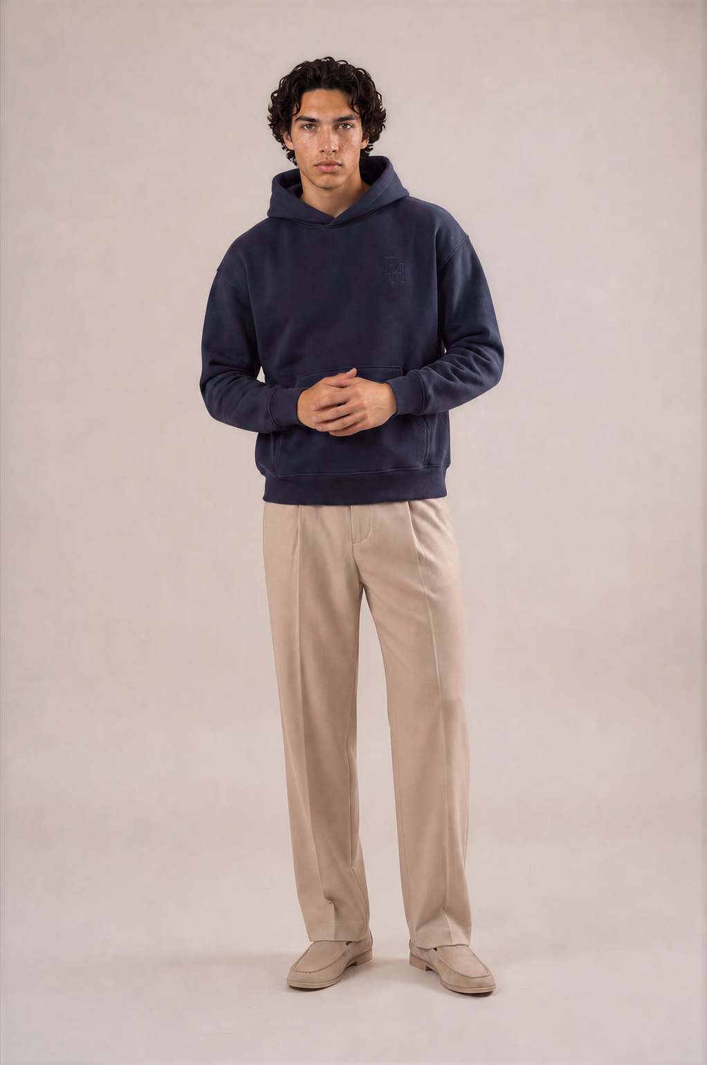 Model wearing the deep navy stringless Dynast Heir hoodie with tonal upper-left chest embroidery